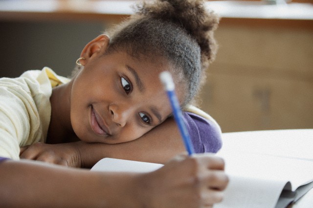 28 Apr 2012 --- Pretty, young student writing at desk. --- Image by © Hero Images/Corbis